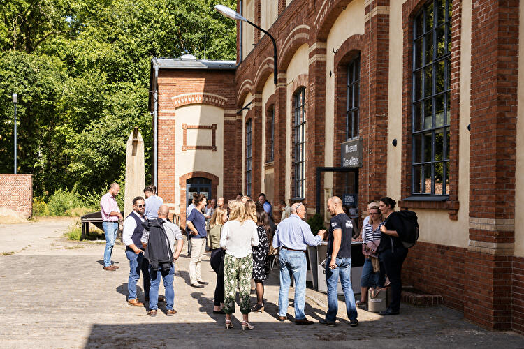 Besucher:innen vor dem Eingang des Museums in einem historischen Backsteingebäude.