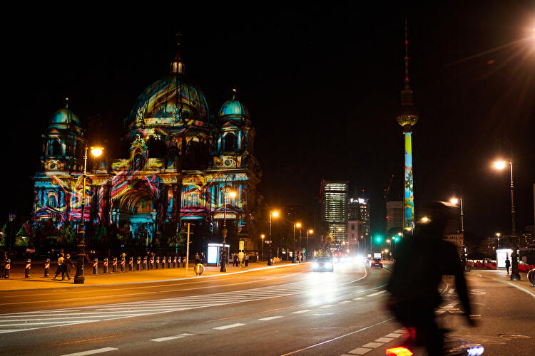 Lichtprojektionen auf dem Berliner Dom und dem Fernsehturm bei Nacht.