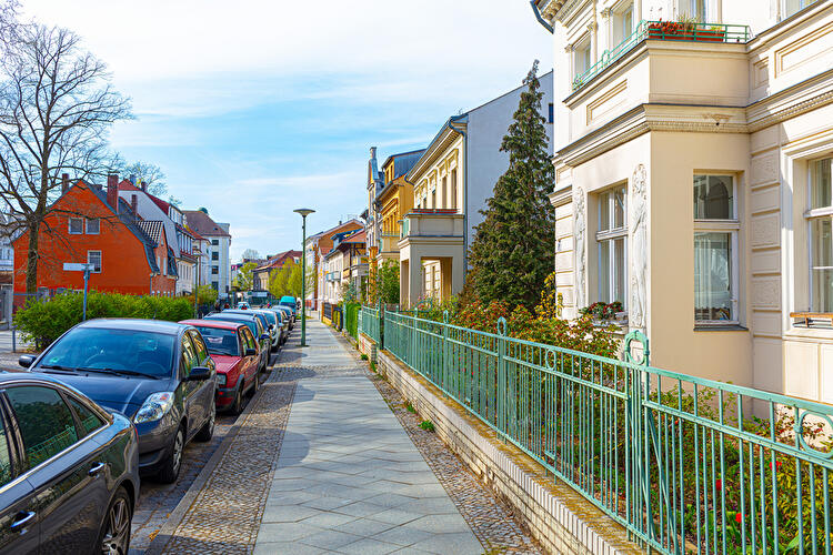 Wohnstraße in Berlin-Friedrichshagen mit Gründerzeitvillen, parkenden Autos und gepflegten Vorgärten.