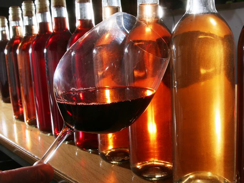 Rotweinglas vor Weinflaschen