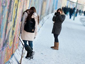 Touristen fotografieren sich vor der East Side Gallery