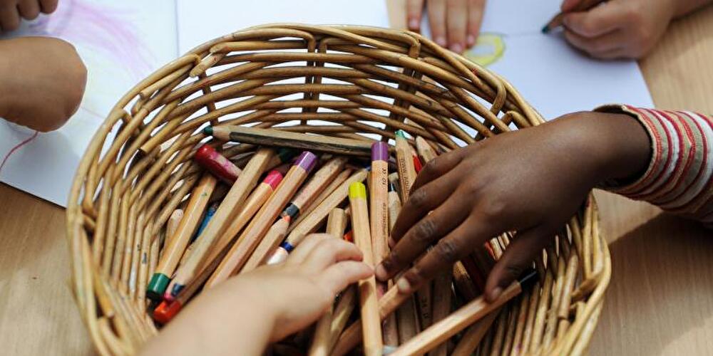 Kinder greifen nach Buntstiften