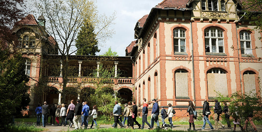 Besuchergruppe vor dem Gebäude der ehemaligen Chirurgie auf dem Gelände der Beelitz-Heilstätten