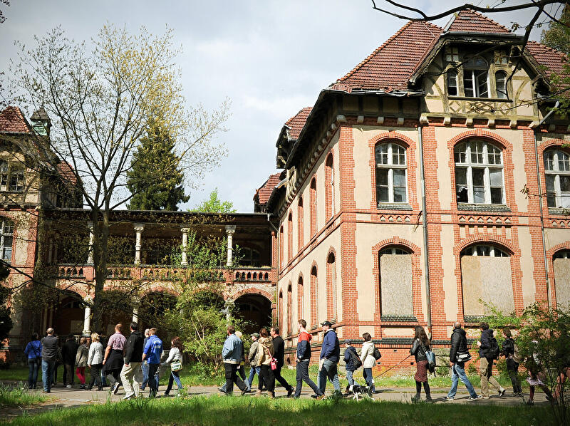 Besuchergruppe vor dem Gebäude der ehemaligen Chirurgie auf dem Gelände der Beelitz-Heilstätten