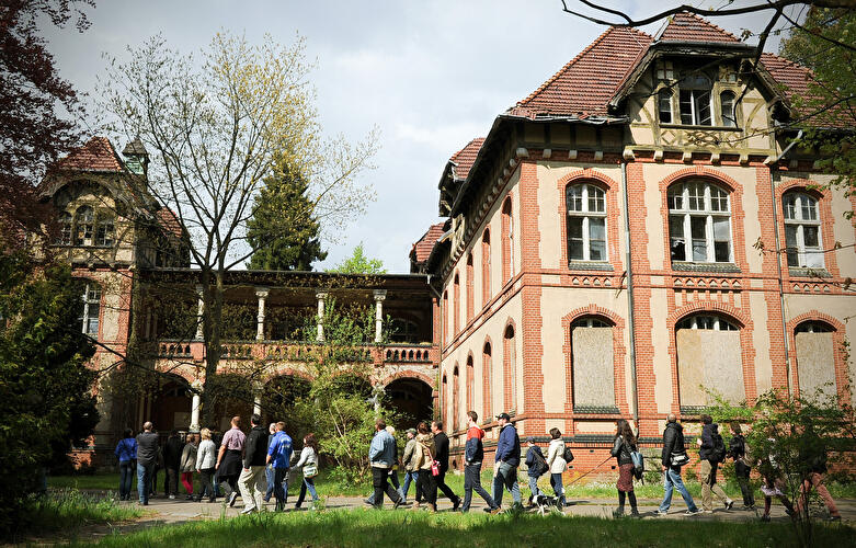 Besuchergruppe vor dem Gebäude der ehemaligen Chirurgie auf dem Gelände der Beelitz-Heilstätten