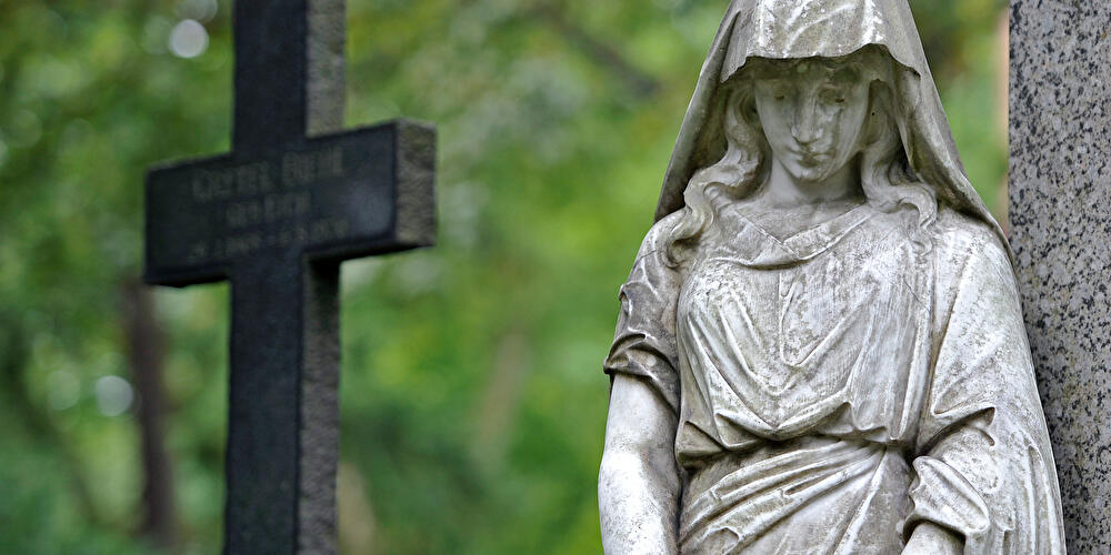 Trauerengel und Kreuz auf einem Friedhof