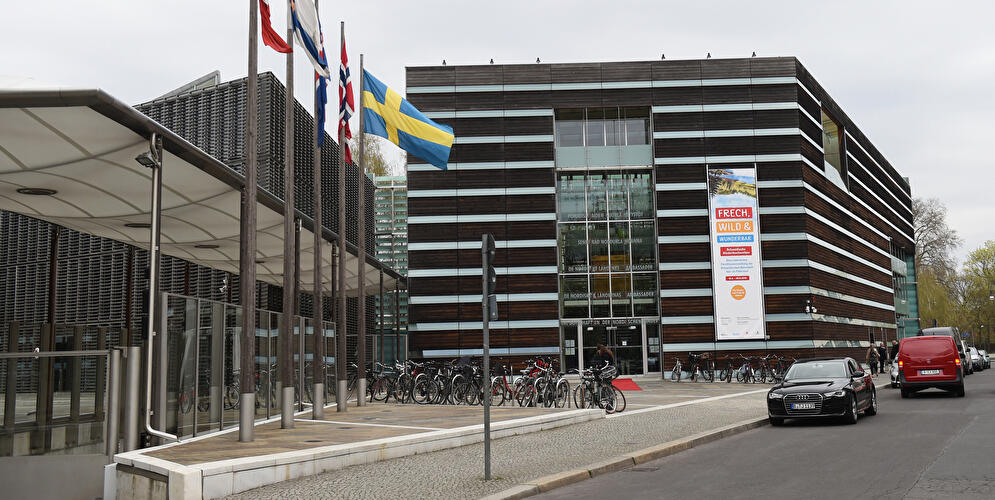 Schwedische Botschaft in Berlin mit Flaggen der nordischen Länder vor dem modernen Botschaftsgebäude.