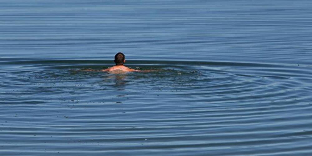 Ein Mann schwimmt im See