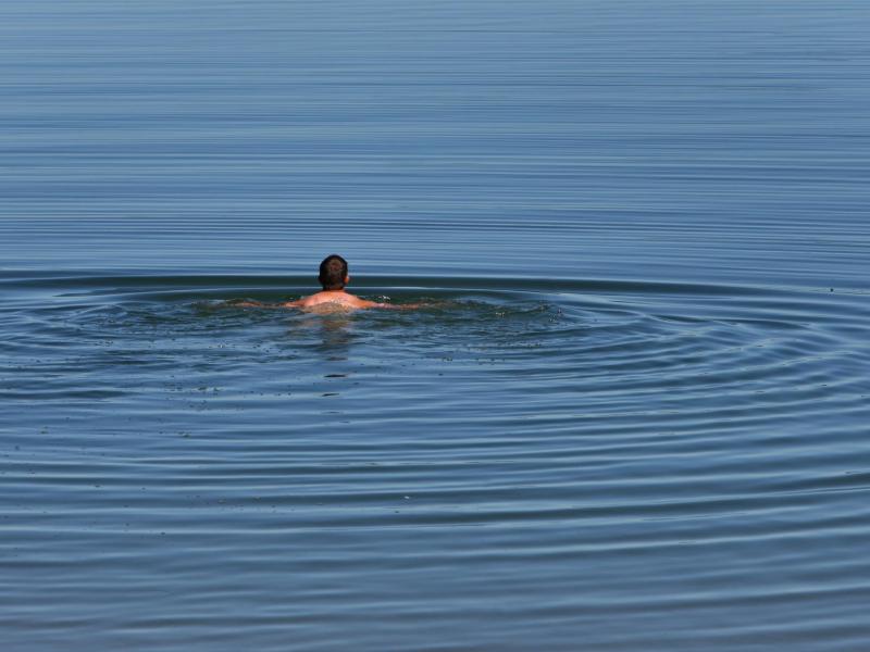 Ein Mann schwimmt im See