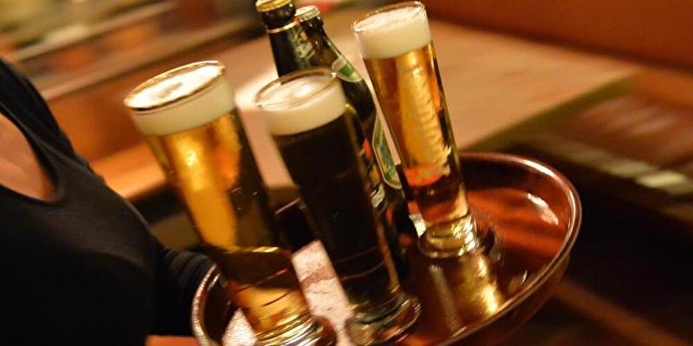 Bedienung trägt Tablett mit Bier