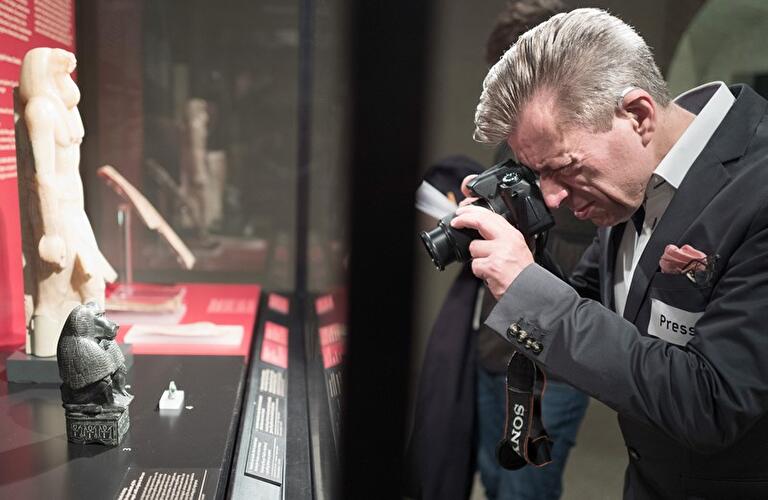 Fotograf vor Statuette des Gottes Thot
