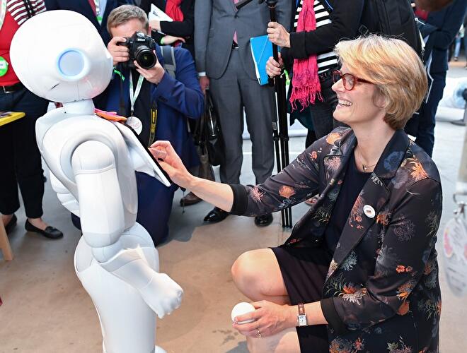 Roboter Pepper (links) und Anja Karliczek (rechts)