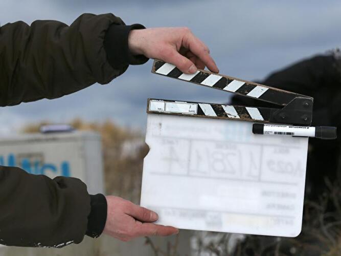 Ein Man hält eine Filmklappe