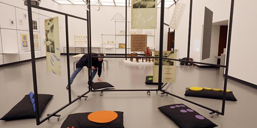 Ein Mann richtet in der Ausstellung ein Objekt aus