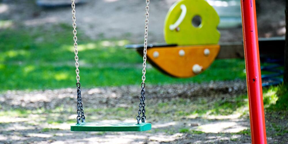 Eine leere Schaukel auf einem Spielplatz