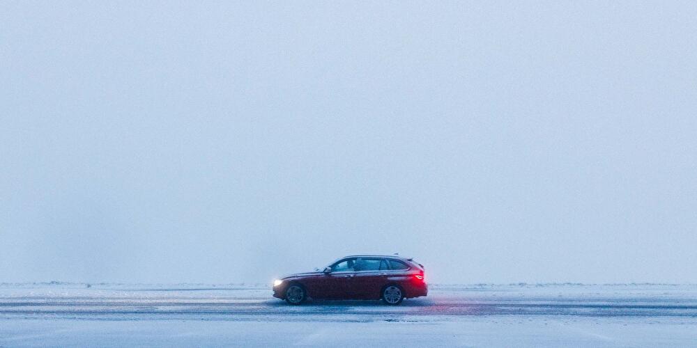 Ein Auto fährt über eine schneebedeckte Straße
