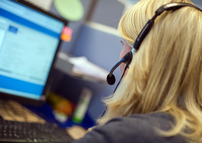 Frau mit Headset am Computer