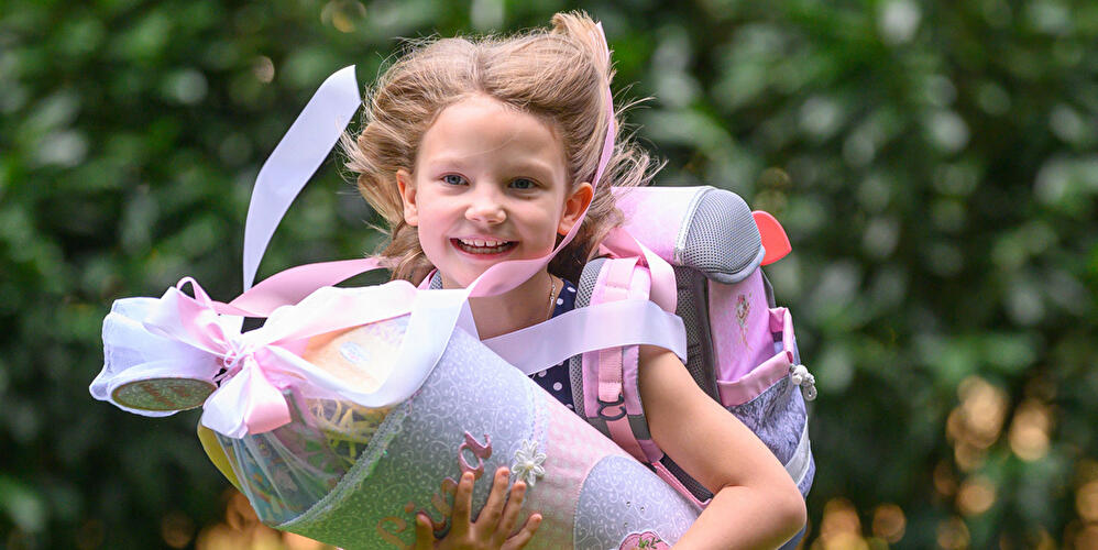 Kind mit Zuckertüte und Ranzen bei der Einschulung