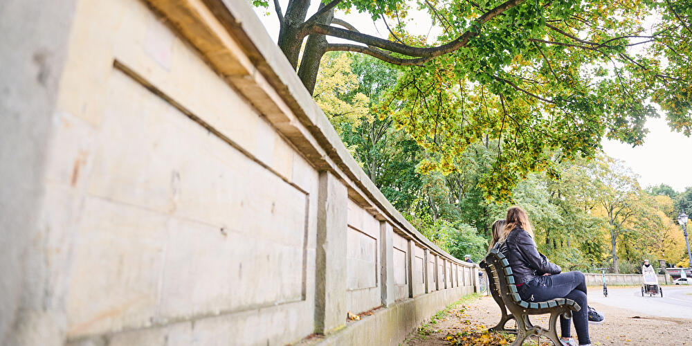 Zwei Frauen sitzen auf einer Parkpank in Berlin
