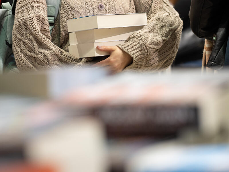 Frau trägt Bücherstapel