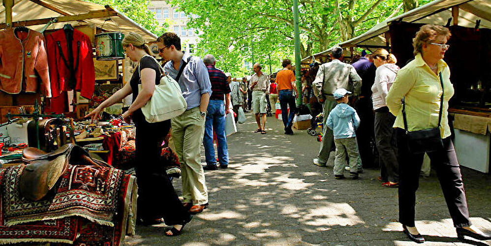 Menschen schlendern über den Flohmarkt am Fehrbelliner Platz