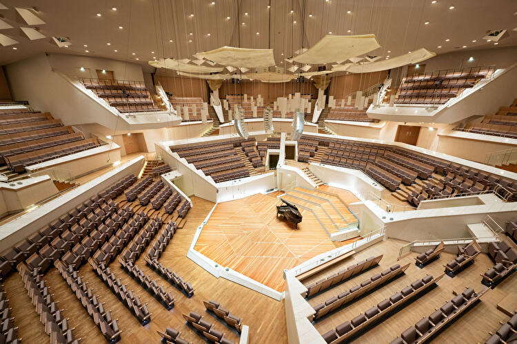 Kammermusiksaal der Berliner Philharmonie mit zentraler Bühne, Flügel und umlaufenden Sitzreihen in terrassenförmiger Anordnung.