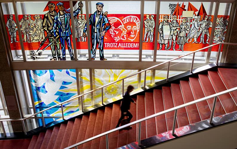 Glasbild von Walter Womacka mit dem Titel „Darstellungen aus der Geschichte der deutschen Arbeiterbewegung“ im Treppenhaus der European School of Management bzw. dem ehemaligen Staatsratsgebäude.