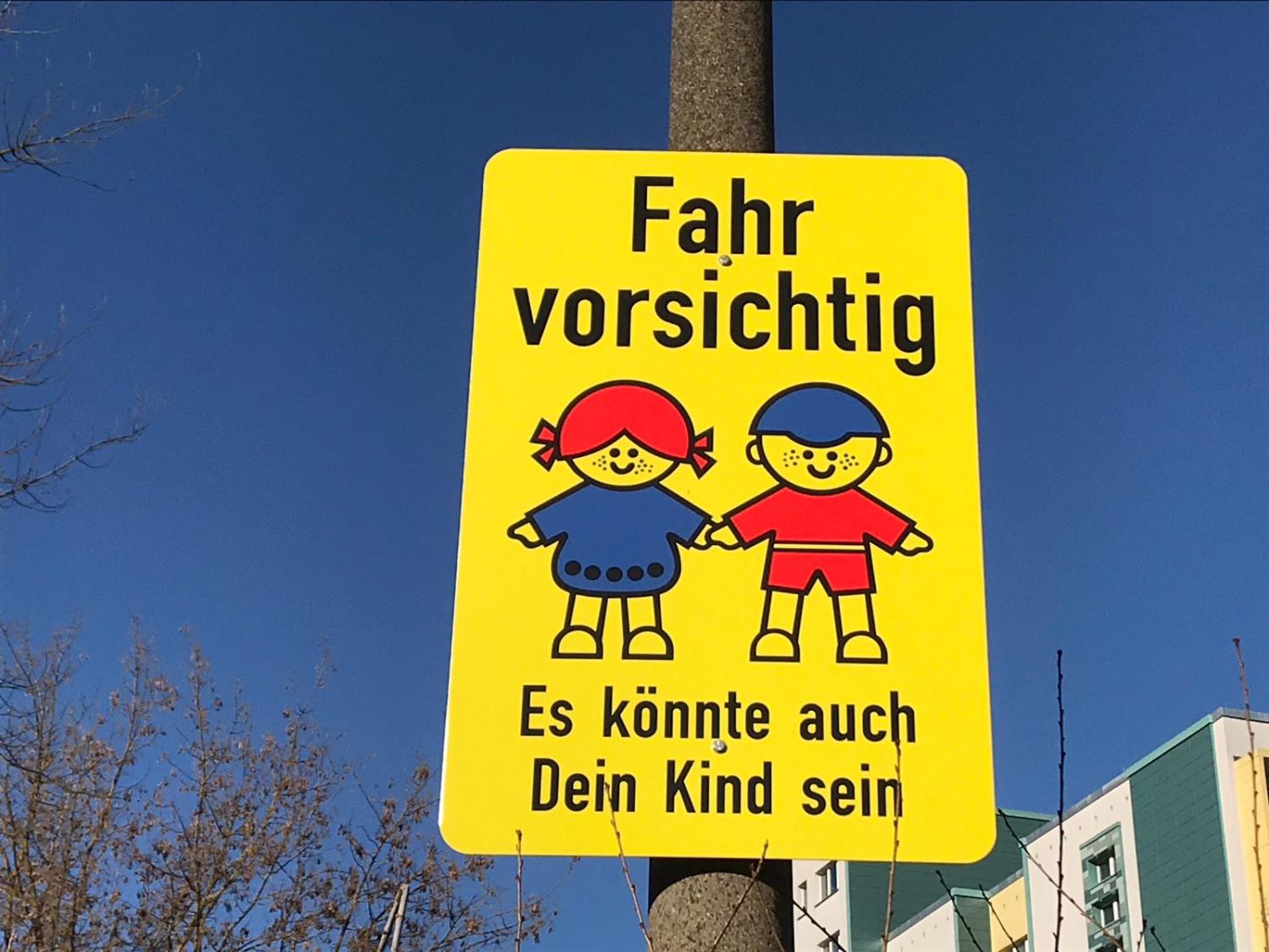 Verkehrsschild mit der Aufschrift "Fahr vorsichtig - Es könnte auch Dein Kind sein"