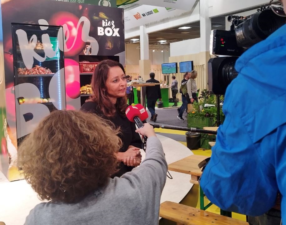 Senatorin Dr. Felor Badenberg gibt ein Interview, im Hintergrund: die Kiezbox