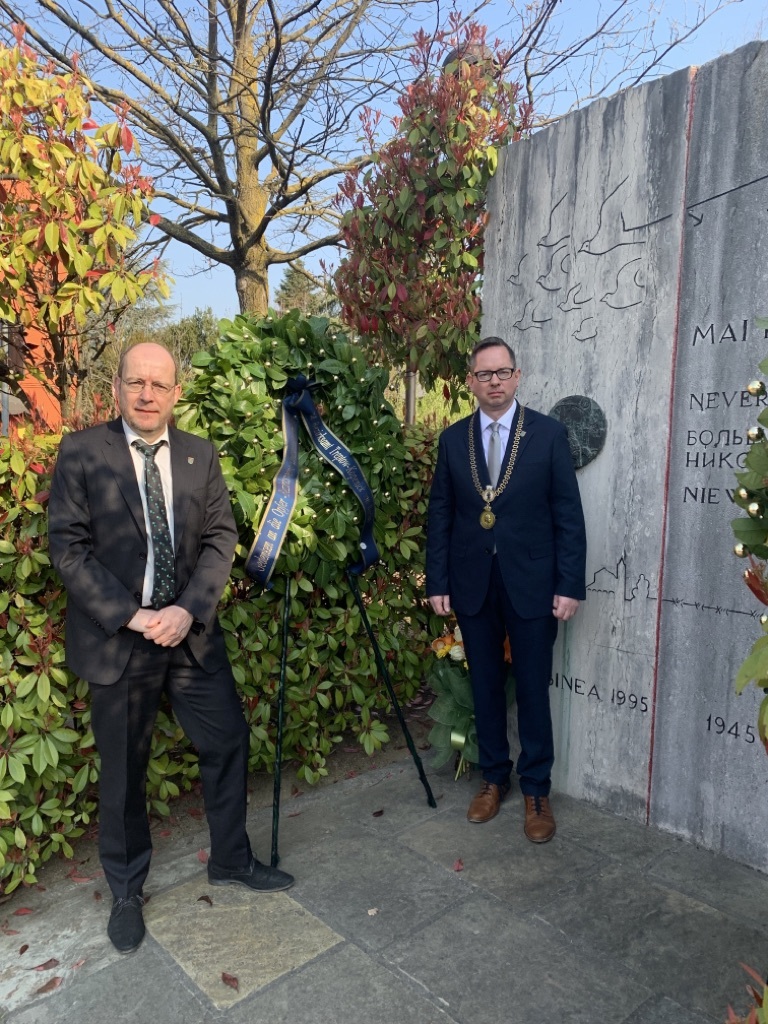 BVV-Vorsteher Groos und Bezirksbürgermeister Igel stehen vor dem Kranz für die Opfer des 2. Weltkrieges in Albinea