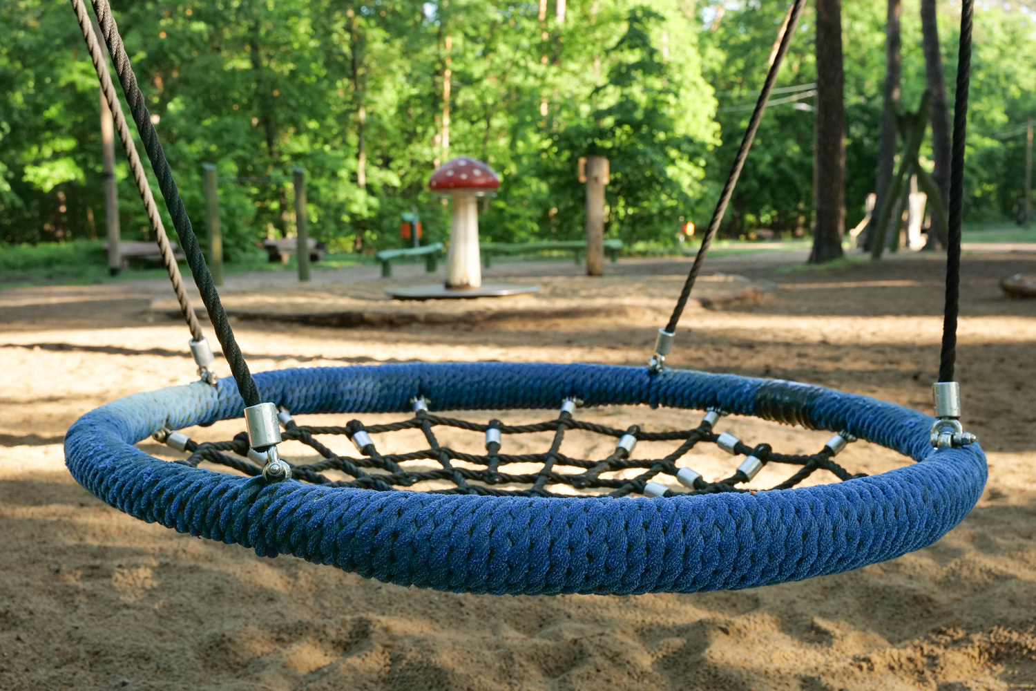 Waldspielplatz Promenade Teufelssee; Nestsschaukel, im Hintergrund Pilzkarussell