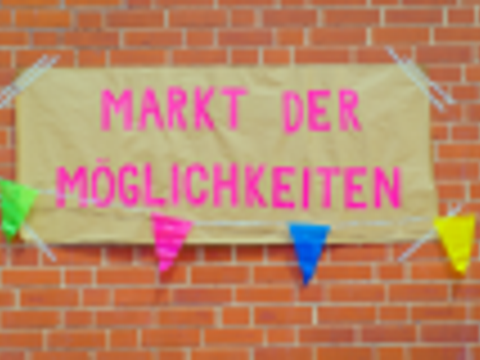 Poster vor einer roten Backsteinwand mit der Aufschrift Markt der Möglichkeiten