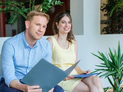 Bewerbende sitzen auf einer Bank