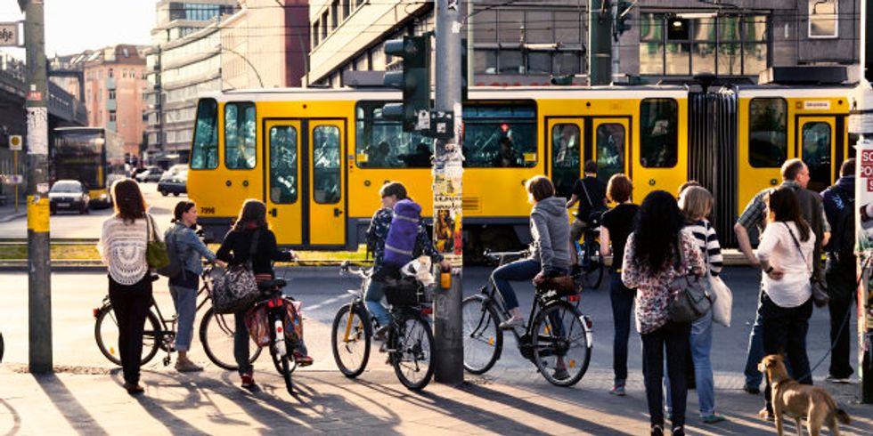 Fußgänger und Fahrradfahrer warten an Ampel