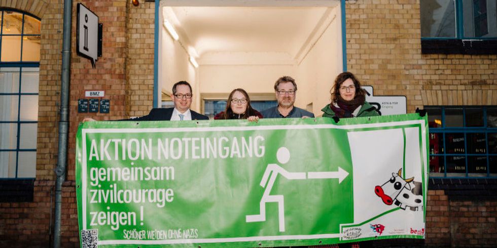 Bezirksbürgermeister Oliver Igel, Joe Goldschmidt von der "Aktion Noteingang", HTW-Präsident Carsten Busch und Claudia Max vom Zentrum für Demokratie halten das Transparent der "Aktion Noteingang" in den Händen