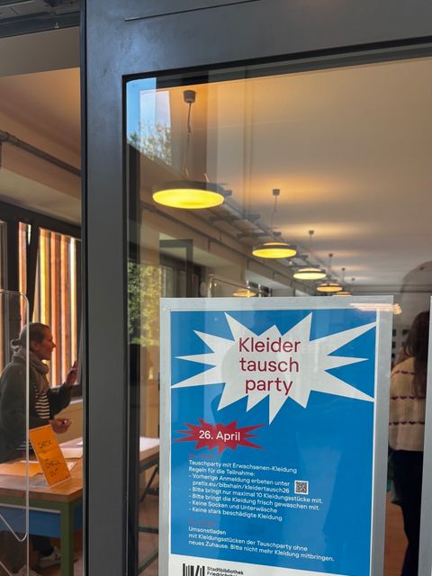 Kleidertauschparty Flyer an Tür vom Werkraum in der Pablo Neruda Bibliothek