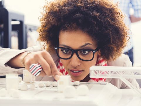 Junge Frau arbeitet an einem Architekturmodell