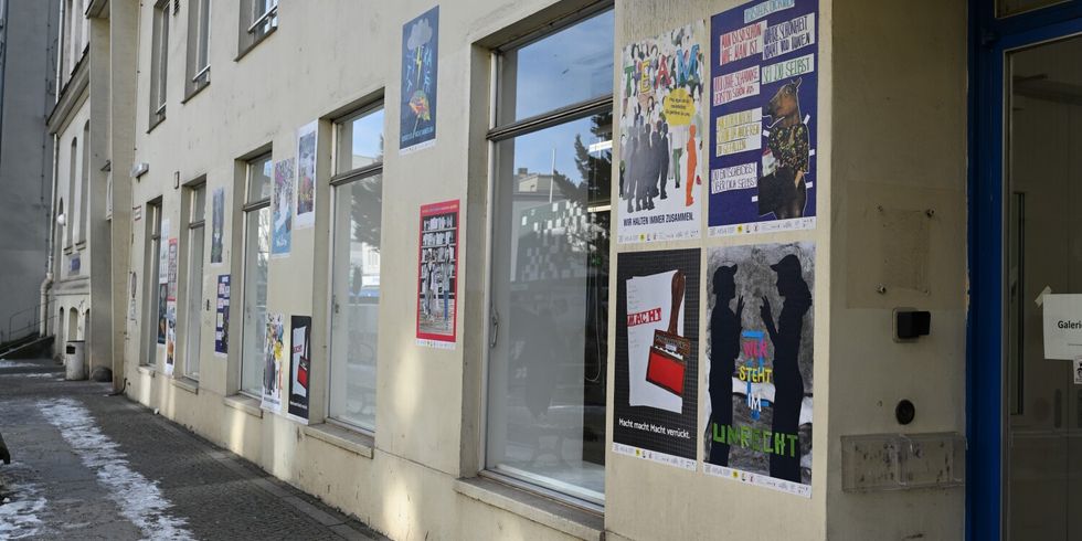 Hausfassade mit bunten Plakaten