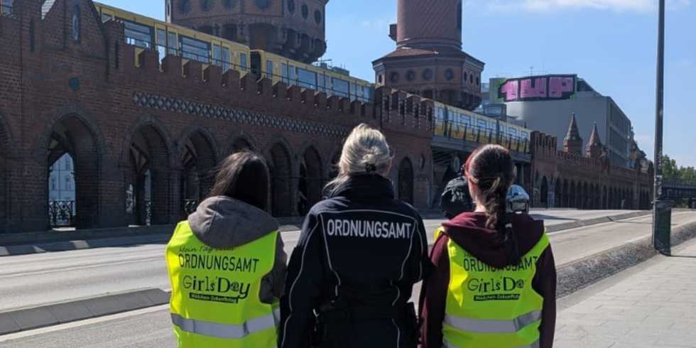Die beiden Teilnehmerinnen des Girls'Day und eine Ordnungsamt-Mitarbeiterin posieren vor der Oberbaumbrücke.