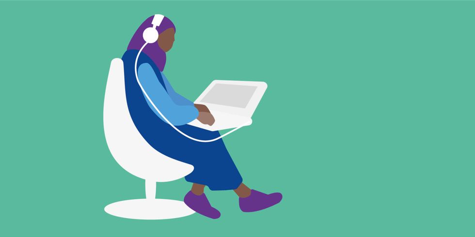 Person mit Kopftuch und Kopfhörern sitzt vor einem Laptop