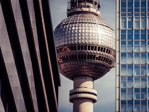 Fernsehturm zwischen zwei Hochhäusern aus unterschiedlichen Epochen.