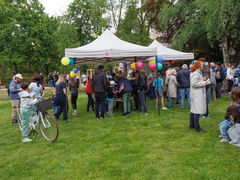 Wiese mit Ballons und vielen Menschen.