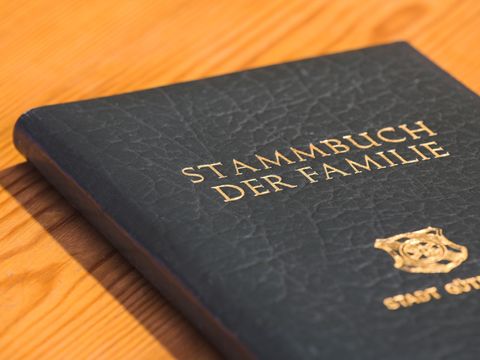 Ein Stammbuch aus schwarzem Leder liegt auf einem Holztisch