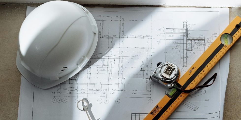 Bauplan, Maßband, Bauhelm und Wasserwaage