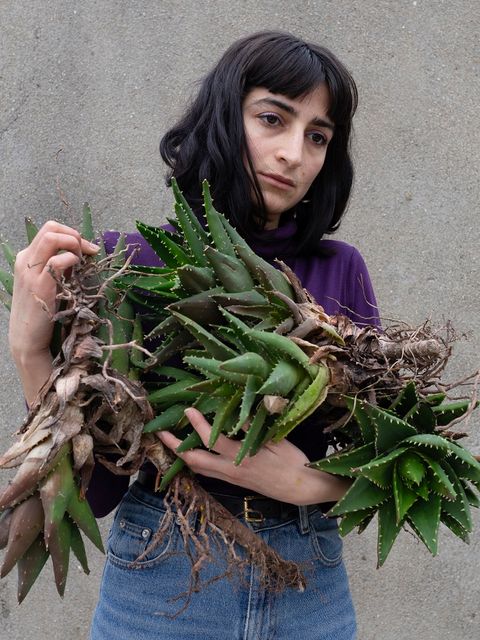 Frau mit Pflanzen im Arm