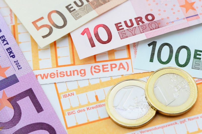 Geldscheine, Münzen und nicht ausgefüllte Überweisungsformulare