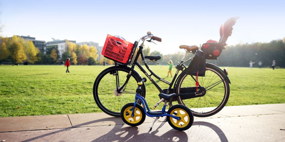 Ein großes und ein Kinderfahrrad stehen auf einem Weg.