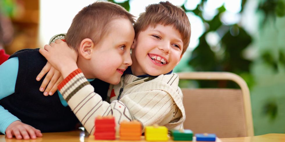 ein kleiner Junge umarmt seinen Spielkameraden