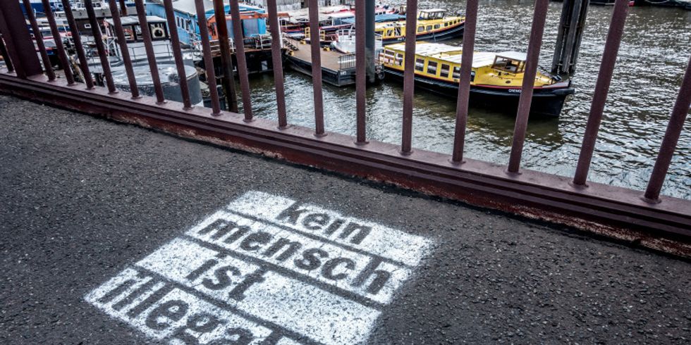 Schriftzug auf den Boden gesprüht kein Mensch ist illegal