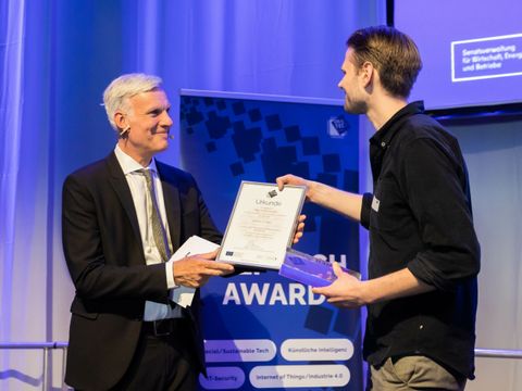 Senator Stefan Schwarz übergibt Urkunde an Tobias Seidl